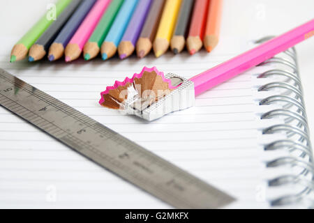 colored pencils on a note pad with a ruler on white background Stock Photo