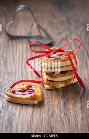 A pile of cookies with jam on a wooden rustic table. Stock Photo