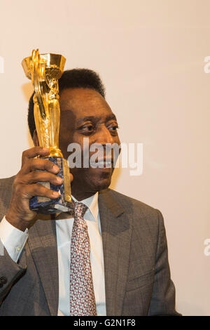 London, UK. 1 June 2016. Pele holds his copy of the Jules Rimet Trophy at a photocall. Brazilian footballing legend attends the press preview of Pele - The Collection, a sale of Pele's personal items run by Julien's Auctions at Mall Galleries in London. Highlights include Pele's Jules Rimet Trophy; 1958, 1962 and 1970 World Cup Medals; Santos FC game worn jerseys and boots; awards received while playing with Santos FC; his 1977 New York Cosmos NASL championship ring; FIFA Player of the Century Award; L'Equipe Athlete of the Century Award; 2007 FIFA President's Award and the torch used by Pele Stock Photo