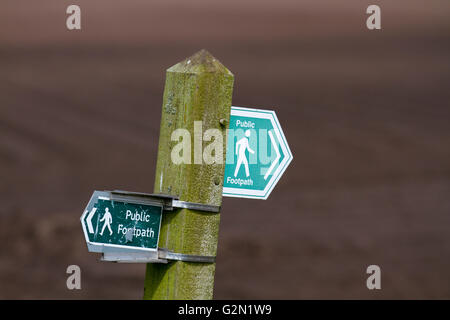 Two different waymarkers indicating Public footpath route signs across farmland in Burscough, Lancashire, UK