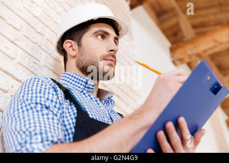 Close-up portrait of a smart pensive builder thinking about something indoors Stock Photo