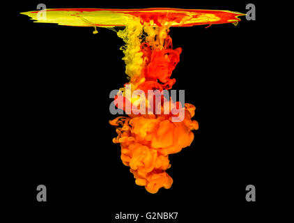 Mix of colored ink in water creating abstract shape, isolated on black background Stock Photo
