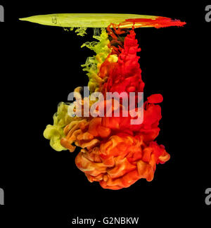 Mix of colored ink in water creating abstract shape, isolated on black background Stock Photo
