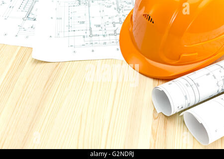 safety helmet with rolled blueprints and construction plans Stock Photo