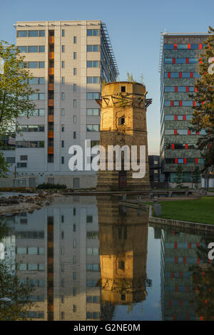 Old abandoned water-tower and modern business buildings side-by-side Stock Photo