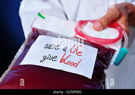 closeup of a young doctor man holding a blood bag with a white label with the text safe a life give blood written in it Stock Photo