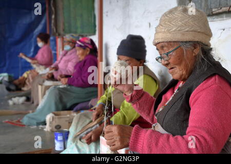 Tibetan women spinning wool at Tashi Palkhel Tibetan refugee camp, Pokhara, Nepal Stock Photo