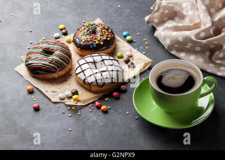 Donuts and coffee on stone table Stock Photo