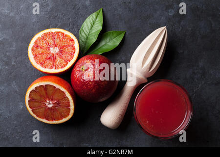 Red oranges and juice glass on stone background. Top view Stock Photo