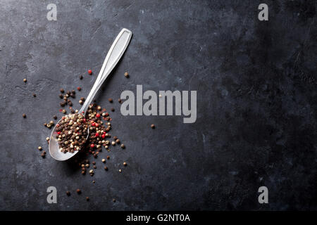 Mixed peppercorn. Red, white and black pepper spices in spoon on stone table. Top view with copy space Stock Photo