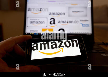 Amazon online retailer logos are pictured on phone and laptop screens. London May 2019. Stock Photo