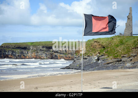 blank flag flying beside surf school with ballybunion castle in background Stock Photo
