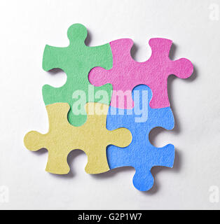 Four colorful puzzle pieces arranged in a square and bonded. Union concept, teamwork and business logo. Stock Photo
