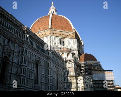 The dome from the Basilica di Santa Maria del Fiore, more commonly called the 'Duomo'. Florence, Italy. Started in 1296 based on Arnolfo di Cambio's design, but was not complete until 1436 when Filippo Brunelleschi engineered the dome. One of Italy's largest churches. The dome itself is octagonal, and uses a double shell design, made of sandstone and marble. Atop the dome sits a lantern with a copper ball and cross at it's peak. Stock Photo