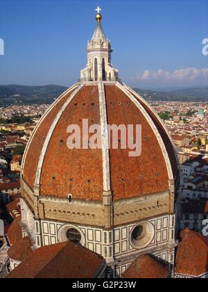 The dome from the Basilica di Santa Maria del Fiore, more commonly called the 'Duomo'. Florence, Italy. Started in 1296 based on Arnolfo di Cambio's design, but was not complete until 1436 when Filippo Brunelleschi engineered the dome. One of Italy's largest churches. The dome itself is octagonal, and uses a double shell design, made of sandstone and marble. Atop the dome sits a lantern with a copper ball and cross at it's peak. Stock Photo