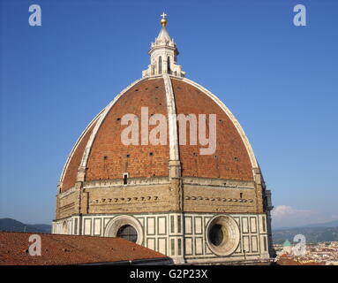 The dome from the Basilica di Santa Maria del Fiore, more commonly called the 'Duomo'. Florence, Italy. Started in 1296 based on Arnolfo di Cambio's design, but was not complete until 1436 when Filippo Brunelleschi engineered the dome. One of Italy's largest churches. The dome itself is octagonal, and uses a double shell design, made of sandstone and marble. Atop the dome sits a lantern with a copper ball and cross at it's peak. Stock Photo