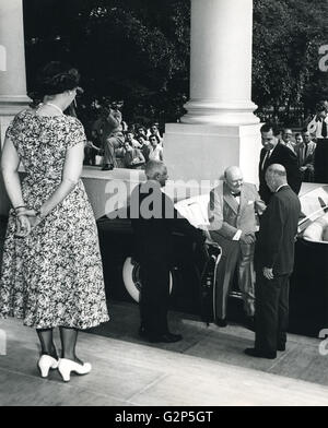 Mamie Eisenhower waits at the top of the steps as President Dwight Eisenhower greets Prime Minister Winston Churchill as he alights from a limousine at the White House. Vice-President Richard Nixon waits behind the British statesman. Stock Photo