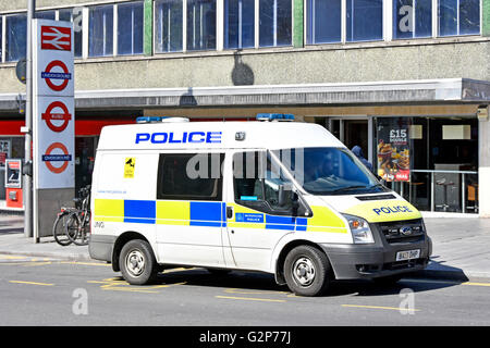 Metropolitan Police van parked outside Barking train station with officer in van talking to people on pavement London Borough of Barking & Dagenham UK Stock Photo