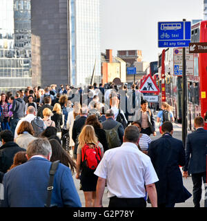 Commuter office workers walking across London Bridge towards London Bridge train station during commuters evening rush hour home England UK Stock Photo