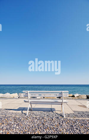 Retro toned empty bench on promenade, space for text. Stock Photo