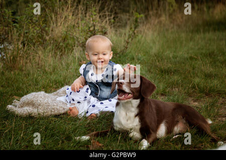 Portrait of a small baby girl at a Lake with a Dog Stock Photo