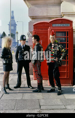 Three punks talking to a policeman by The Houses of Parliament. London. England. UK. Europe. Circa 1980's Stock Photo