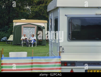 An elderly couple relaxing at a caravan park. Cambridgeshire. England. UK Stock Photo