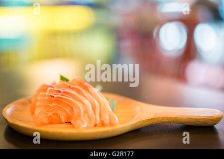 Sliced salmon sashimi served on wooden platter, Japanese food delicious menu, bokeh blurred background with copy space Stock Photo