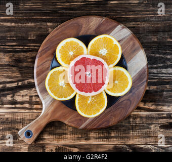 Orange and Grapefruit slices arranged on a plate in a flower shape. Top view Stock Photo