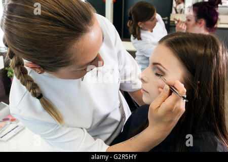 Beautician makeup a young woman. Stock Photo