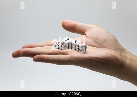 Human hand ready to roll the dice on white isolated background - Try luck, Take Risk or Business concept (Focus on dices) Stock Photo