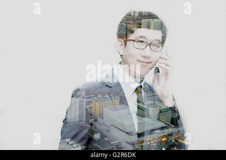 Double exposure of businessman talking on the phone with cityscape scene. Stock Photo
