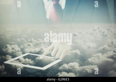 Double exposure of Businessman touching on tablet dissolved with clouds on the sky background. Stock Photo