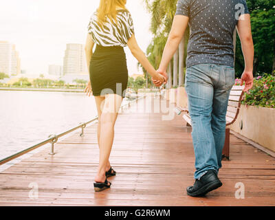 Couple in love holding hands with each other on the pier Stock Photo