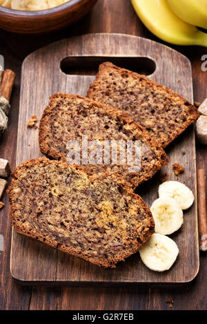 Slices of banana bread on wooden cutting board, top view Stock Photo