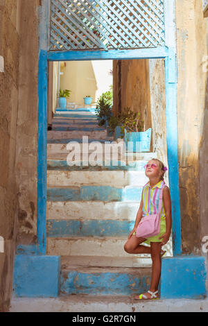 ALICANTE, SPAIN - SEPTEMBER 9, 2014: Beautiful girl in pink glasses standing near the stairs going up on popular tourist street Stock Photo