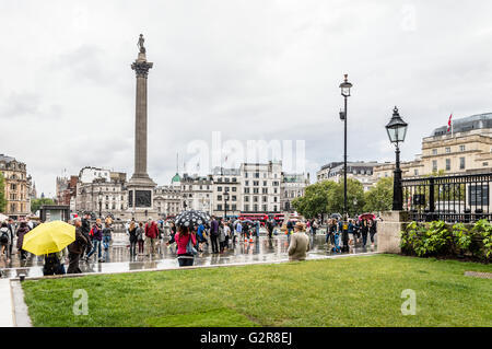 LONDON, UK - AUGUST 24, 2015: Crowd in Trafalgar Square a rainy day of summer. Stock Photo