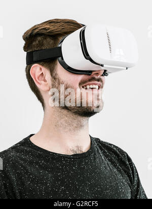 A Close up of a man with a virtual reality headset against a plain white background Stock Photo
