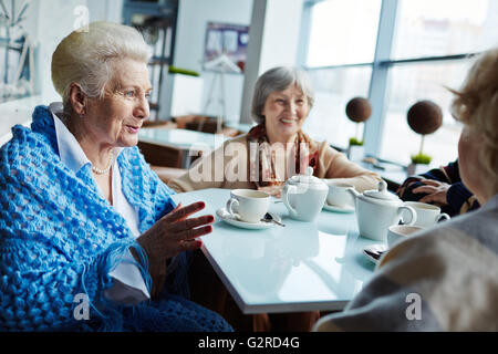 Modern seniors talking in cafe Stock Photo