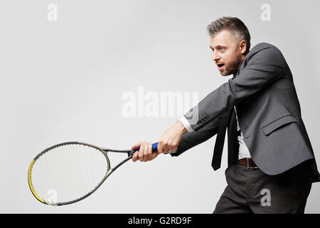 Confident employer in smart suit artfully playing tennis with his business rival, the idea of image is professionalism of modern Stock Photo