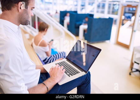 Handsome white man using his new laptop while sitting down Stock Photo