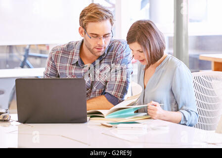 Adult male and female business partners busy working in office Stock Photo