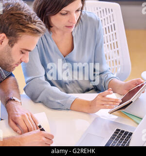 man and woman working together closely at work in office Stock Photo