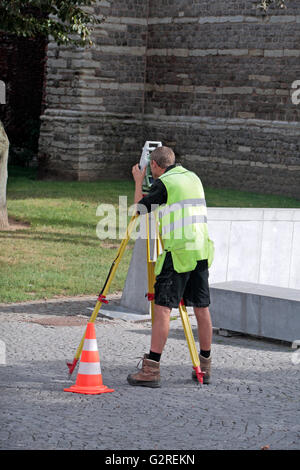 A Civil Engineer using an electronic theodolite on a tripod in Sint Truidenn, Limburg, Belgium. Stock Photo