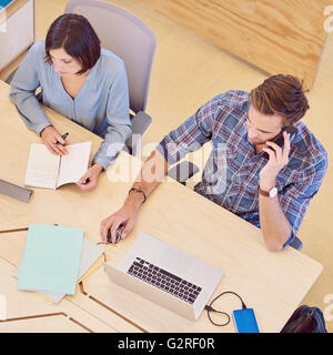 Overhead shot of man and woman busy working together Stock Photo