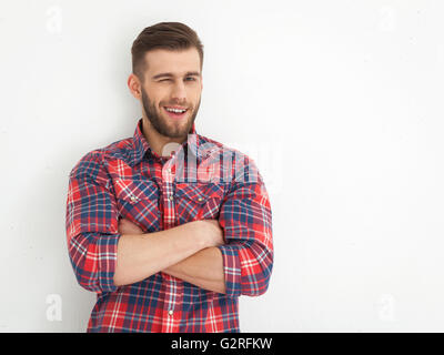 Portrait of handsome young guy standing against white wall. Stock Photo