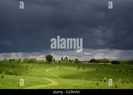 Footpath lit up against a dark stormy sky through an Oxfordshire field. Banbury, Oxfordshire, England Stock Photo