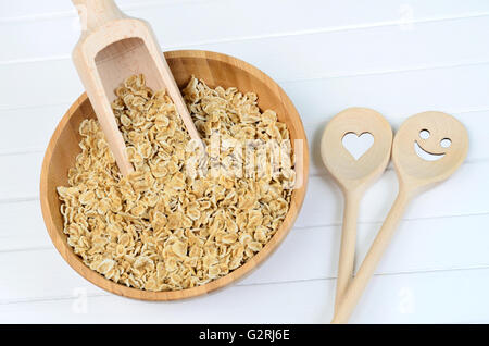 Bamboo bowl with oats and lovely wooden spoon on table Stock Photo