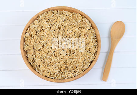 Bamboo bowl with oats on white wooden table Stock Photo