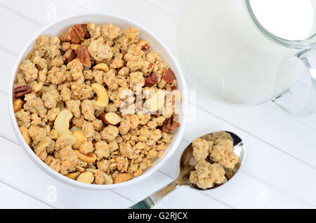 Healthy muesli in bowl with milk on white wooden table Stock Photo
